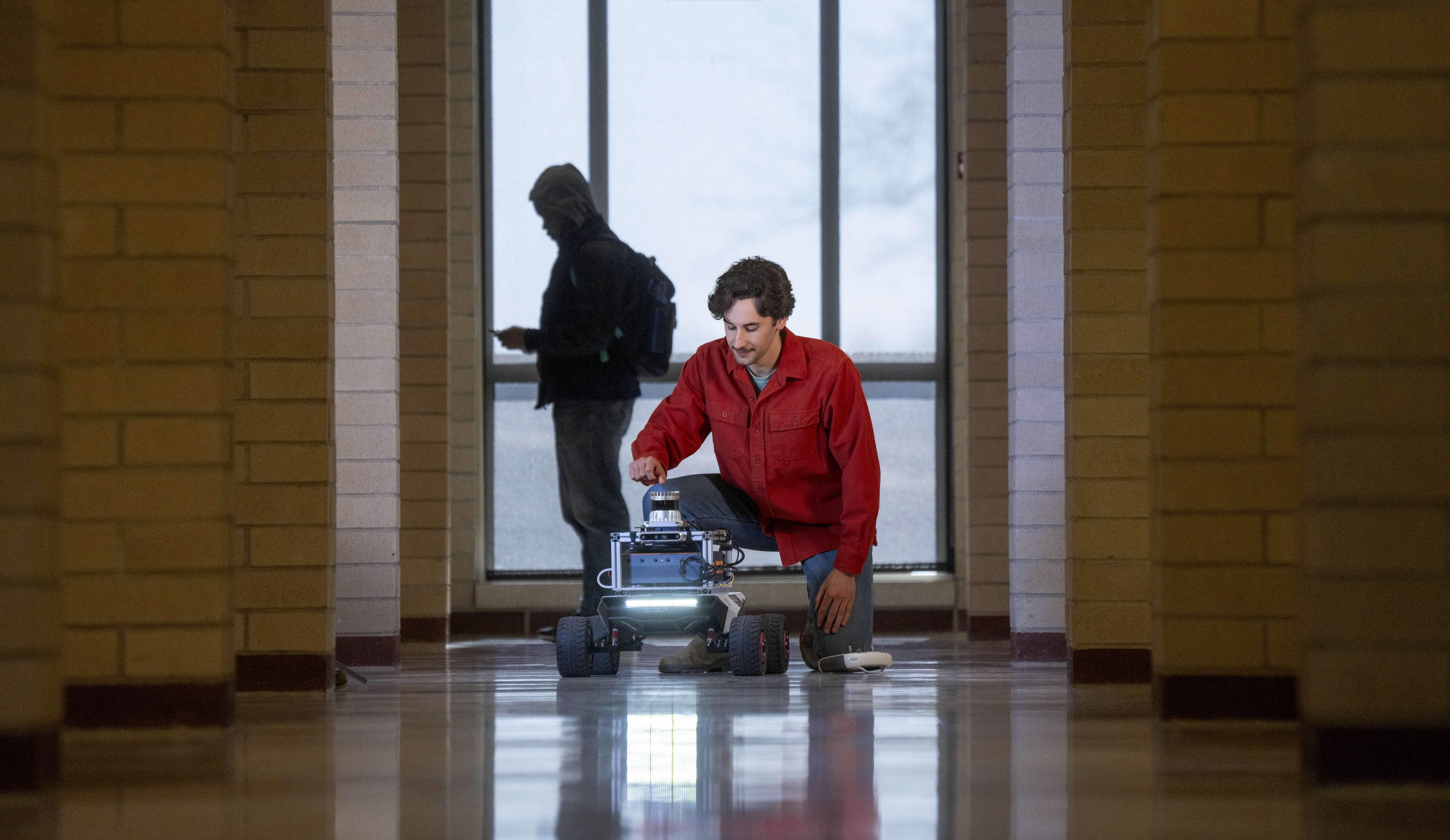 Ori Miller in a hallway with a robot