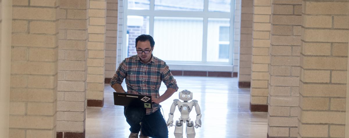 student with robot in hallway