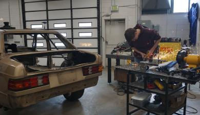 Fourth-year student Jackson Bolinger works on parts for the Mercedes 190 that Time Attack hopes to race at Pikes Peak.