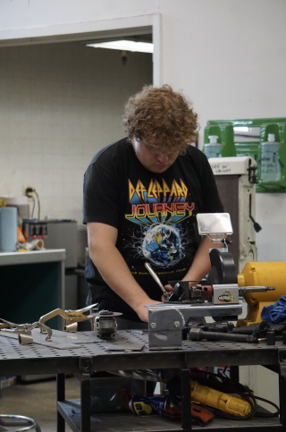 Fourth-year student Malcolm Morris-Berlin puts on a pair of goggles and works on car parts in the Time Attack shop.